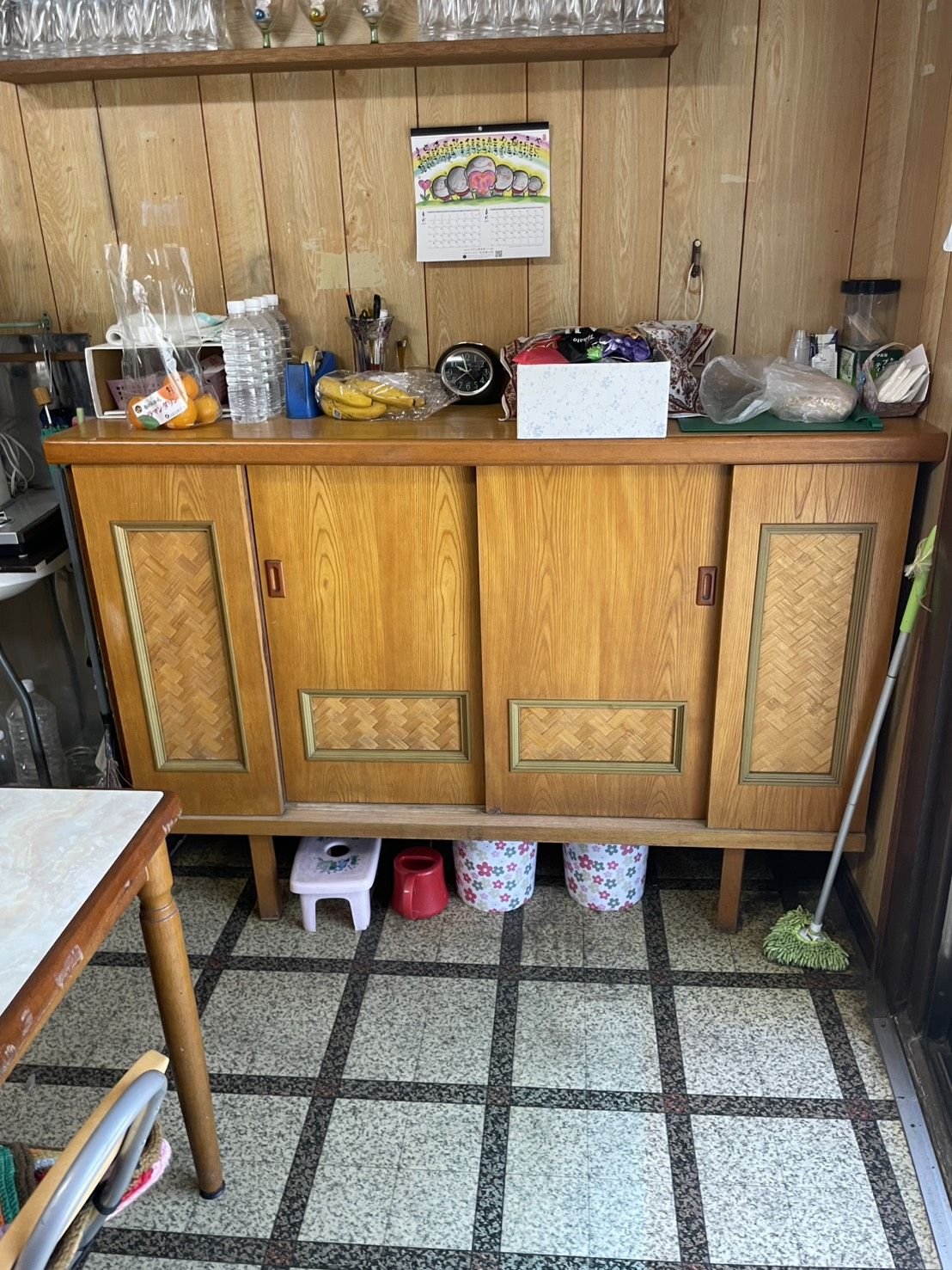 空き家の台所。タイルの床と古い食器棚